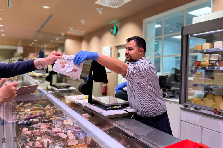 Ein Kutsche-Mitarbeiter bedient eine Kunden an der Frischetheke in Belm